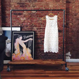 Monroe Trades signature clothing rack with poster and white dress