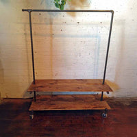 Rolling clothing rack with two bottom wood shelves and top hang bar.