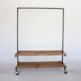 Industrial clothing rack with top bar and two wood shelves 