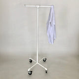 Monroe Trades mobile clothing T shape rack with casters, painted white with a white shirt hanging on it