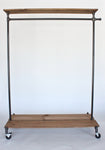 Industrial clothing rack with distressed wood platforms and top shelf