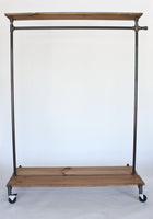 Industrial clothing rack with distressed wood platforms and top shelf