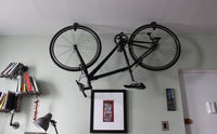 Bike hanging from rubber coated ceiling hooks in organized apartment 