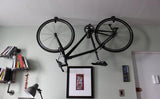 Bike hanging from rubber coated ceiling hooks in organized apartment 